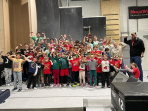 a group of kids with arms flexed above their heads